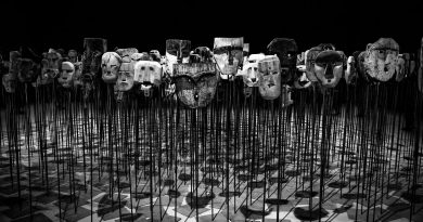 greyscale photo of masks on a stick