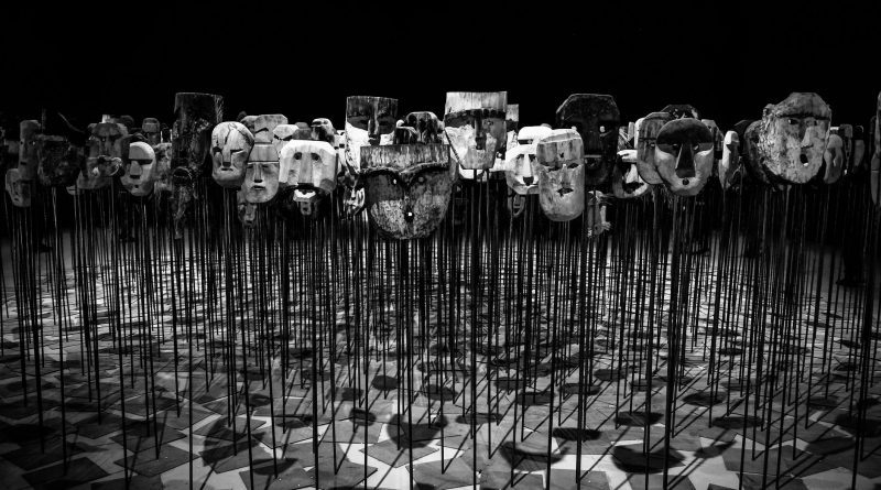 greyscale photo of masks on a stick
